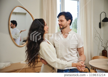 Couple smiling and enjoying a cozy moment in a modern living room Couple smiling and enjoying a cozy moment in a modern living room 119631214
