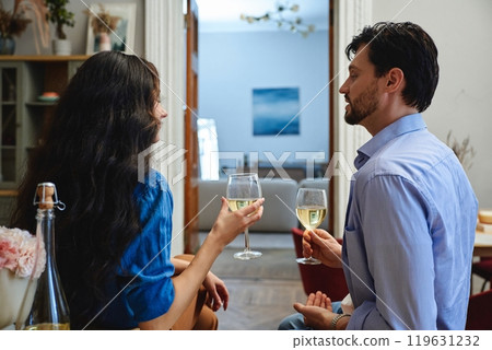 Romantic evening conversation between a couple with wine in cozy living room 119631232