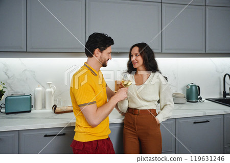 Young couple enjoying a toast in a modern kitchen at home Young couple enjoying a toast in a modern kitchen at home 119631246