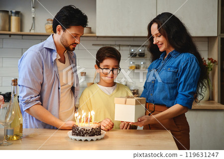 Celebrating a childs birthday with cake, gifts, and family joy at home Celebrating a childs birthday with cake, gifts, and family joy at home 119631247