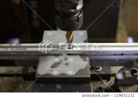 Drilling holes into an aluminum frame at a machining center Drilling holes into an aluminum frame at a machining center 119632132