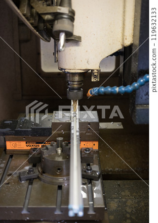 Drilling holes into an aluminum frame at a machining center Drilling holes into an aluminum frame at a machining center 119632133