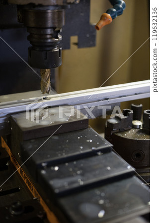 Drilling holes into an aluminum frame at a machining center Drilling holes into an aluminum frame at a machining center 119632136