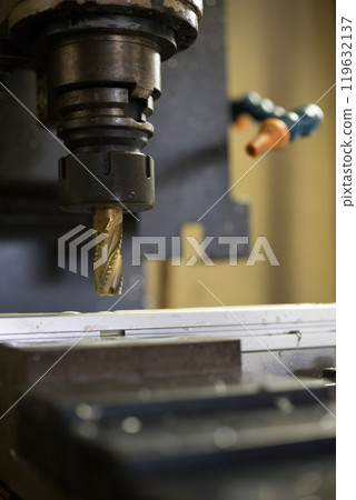 Drilling holes into an aluminum frame at a machining center Drilling holes into an aluminum frame at a machining center 119632137