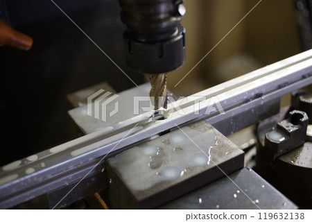 Drilling holes into an aluminum frame at a machining center 119632138