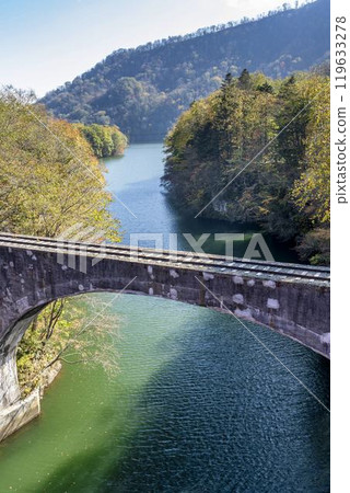 Aerial view of the remains of the Shihoro Line's Third Otofuke River Bridge from Sensui Bridge on a clear autumn day, Kamishihoro Town, Hokkaido 119633278