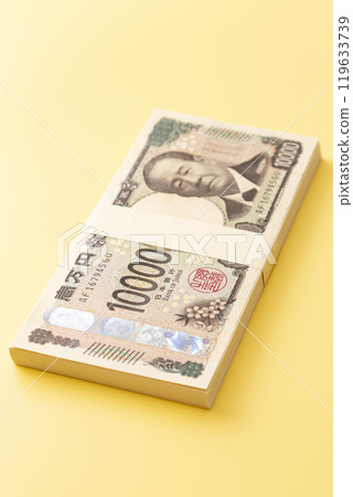 黃色背景上的一疊 10,000 日元鈔票 119633739