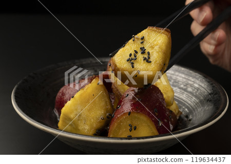 Daigakuimo (sweet potato) Pick up the sweet potato covered in sauce with chopsticks Daigakuimo (sweet potato) Pick up the sweet potato covered in sauce with chopsticks 119634437