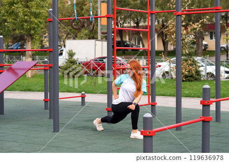 Woman performing lunges during outdoor exercise at playground Woman performing lunges during outdoor exercise at playground 119636978
