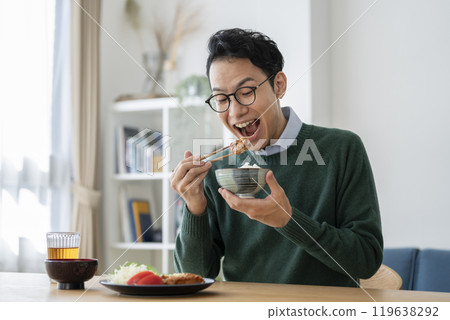 A man in his late 30s eating rice 119638292
