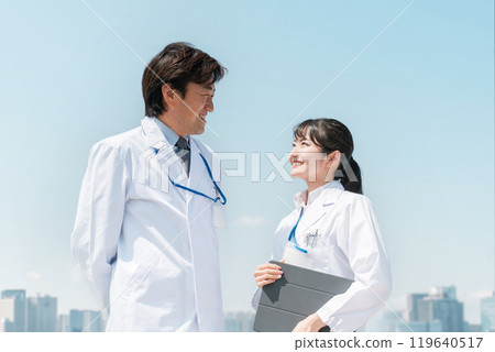 醫生、醫生、醫務工作者、醫生、藥劑師和研究人員的男女在醫院屋頂上交談 119640517
