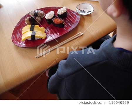 Child eating sushi (back view) 119640939