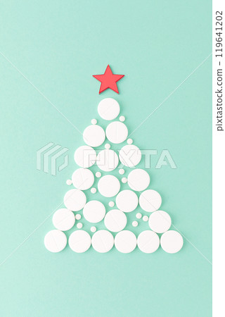 Christmas tree of white pills with star on top, flat lay on green background. Medical holiday concept, copy space. Health and wellness theme, festive composition for seasonal and healthcare designs, Christmas tree of white pills with star on top, flat lay on green background. Medical holiday concept, copy space. Health and wellness theme, festive composition for seasonal and healthcare designs, 119641202