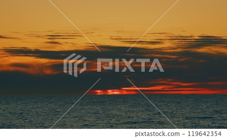Amazing Colors Sun Setting Down Over The Ocean. Variety Of Colors And Hues Of Setting Sun. Still. Amazing Colors Sun Setting Down Over The Ocean. Variety Of Colors And Hues Of Setting Sun. Still. 119642354