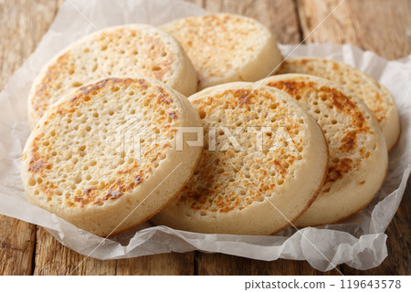 Tradition hot buttered crumpets closeup on parchment. Horizontal 119643578