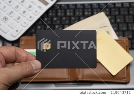 Online shopping with a black credit card held in hand Online shopping with a black credit card held in hand 119643711