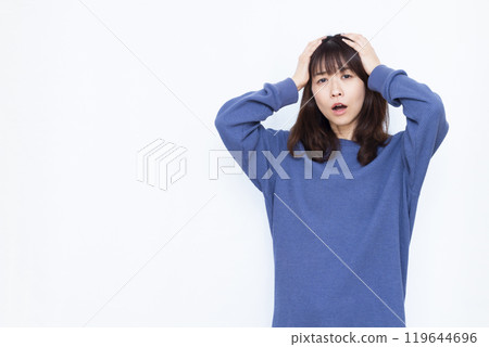A surprised woman holding her head 119644696