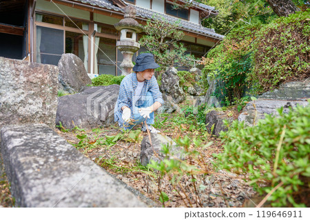 Woman taking care of the garden, Japanese garden, countryside, vacant house, weeding Woman taking care of the garden, Japanese garden, countryside, vacant house, weeding 119646911