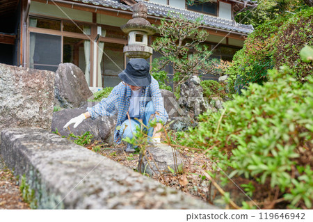 Woman taking care of the garden, Japanese garden, countryside, vacant house, weeding Woman taking care of the garden, Japanese garden, countryside, vacant house, weeding 119646942