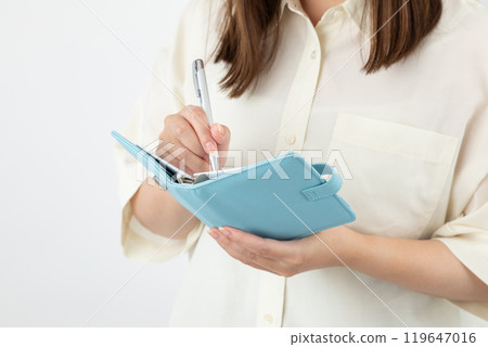 Woman writing in notebook 01 Woman writing in notebook 01 119647016