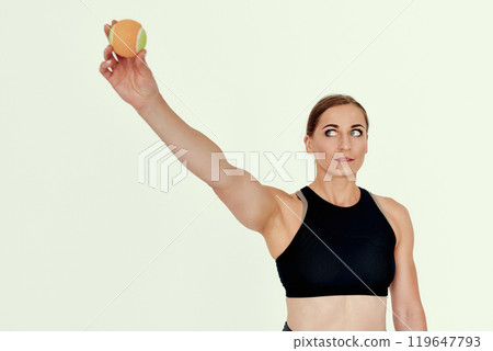 Focused Trainer Holding Tennis Ball Overhead. 119647793