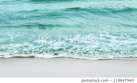 Stunning view of azure ocean waves gently crashing onto a pristine sandy beach, evoking a sense of relaxation and escape. The image conveys the idea of a perfect vacation by the sea. Stunning view of azure ocean waves gently crashing onto a pristine sandy beach, evoking a sense of relaxation and escape. The image conveys the idea of a perfect vacation by the sea. 119647940