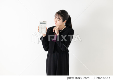 A woman in mourning clothes holding a calculator A woman in mourning clothes holding a calculator 119648853