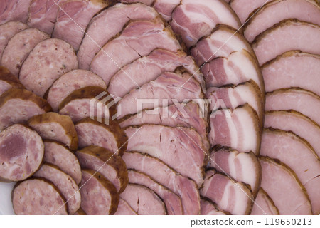 Close-up of assorted smoked sausages and ham slices 119650213