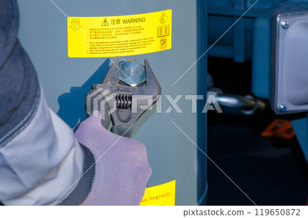 Technician Uses Adjustable Wrench to Fill Oil into Compressor Technician Uses Adjustable Wrench to Fill Oil into Compressor 119650872