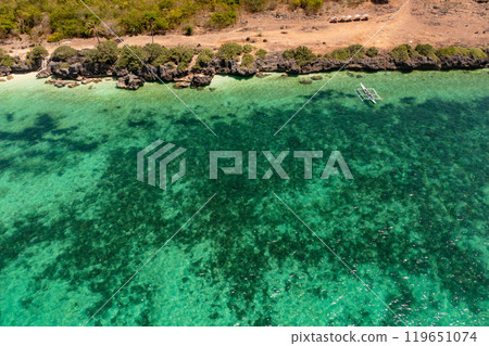 Coastline with cliffs and clear turquoise waters. Boat and coral reefs in tropical island. Bantayan, Cebu, Philippines. Coastline with cliffs and clear turquoise waters. Boat and coral reefs in tropical island. Bantayan, Cebu, Philippines. 119651074