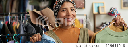 Happy young female consumer with shirts Happy young female consumer with shirts 119651648