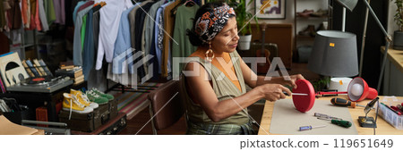 Young woman repairing electric lamp 119651649