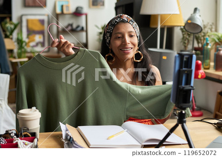 Showing new pullover to online audience 119652072