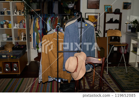 Two beige hats on back of wooden chair Two beige hats on back of wooden chair 119652085