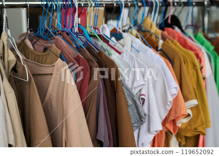 Casual attire of various colors on rack 119652092