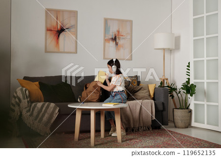 Young Girl Listening To Music In Living Room Young Girl Listening To Music In Living Room 119652135