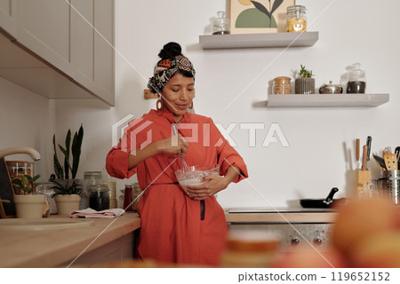 Mixing Ingredients in Cozy Home Kitchen Setting 119652152