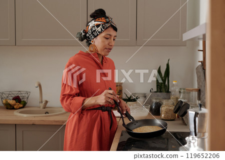 Woman Wearing Bandana Cooking in Kitchen 119652206