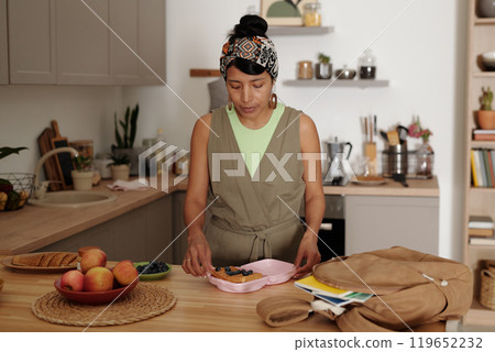 Woman Preparing Breakfast in Cozy Kitchen Setting Woman Preparing Breakfast in Cozy Kitchen Setting 119652232