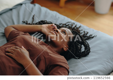 Smiling Woman Lying on Bed and Relaxing Smiling Woman Lying on Bed and Relaxing 119652566