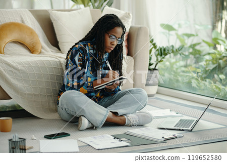 Woman Analyzing Notes in Cozy Living Room Setting 119652580