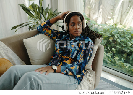 Listening to Music in Cozy Living Room Setting Listening to Music in Cozy Living Room Setting 119652589