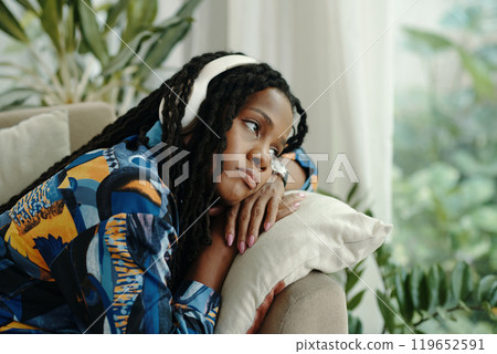 Relaxing Woman Leaning on Pillow Wearing Patterned Shirt Relaxing Woman Leaning on Pillow Wearing Patterned Shirt 119652591