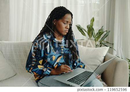 Focused Professional Working on Laptop at Home Focused Professional Working on Laptop at Home 119652596