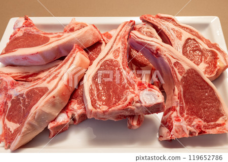 Fresh New Zealand lamb ribs on plate marbled tender meat layers ready for grilling Fresh New Zealand lamb ribs on plate marbled tender meat layers ready for grilling 119652786