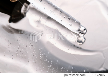 Dropper pipette with delicious serum with bubbles on the gel texture. 119652807