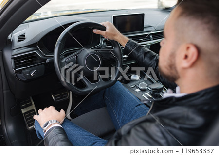 View from above on man driving the car. Focus of steering wheel. Luxury car 119653337