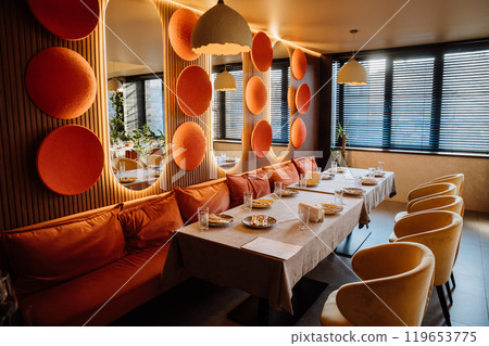 Sunlit restaurant table with elegant glassware, decor, and a warm, cozy ambiance Sunlit restaurant table with elegant glassware, decor, and a warm, cozy ambiance 119653775