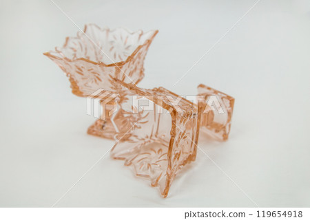 Two empty crystal cremans or vases on a stem for ice cream or salads of peach or orange color lie on a white background and close-up. High quality photo Two empty crystal cremans or vases on a stem for ice cream or salads of peach or orange color lie on a white background and close-up. High quality photo 119654918