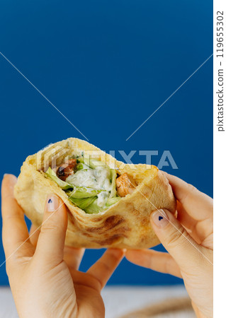 Pita wrap filled with grilled chicken, lettuce, and creamy sauce, healthy fast food on the go Pita wrap filled with grilled chicken, lettuce, and creamy sauce, healthy fast food on the go 119655302